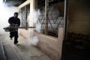 Un trabajador municipal fumiga una escuela pública para erradicar el mosquito Aedes aegypti, transmisor del zika, en Tegucigalpa, Honduras, 2 de febrero de 2016. (AP Foto/Fernando Antonio)