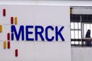Un trabajador de Merck KGaA cerca del logo de la compañía, cuya sede está ubicada en Darmstadt, Alemania. EFE/Archivo