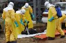 Varios especialistas de la salud transportan el cuerpo sin vida de una víctima del ébola en Paynesville, a las afueras de Monrovia (Liberia) hoy, martes 9 de septiembre del 2014. EFE