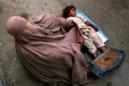 Una mujer con burka y su hija piden limosna en una calle de Peshawar (Pakistán). EFE/Archivo