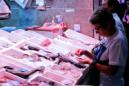 Una mujer en un puesto de pescado del mercado de Antón Martín, en Madrid. EFE