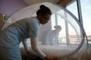 Enfermeras colocan un mosquitero en una cama de hospital, parte de las medidas preventivas que se usan para tratar a pacientes infectados con el virus de Zika, en Singapur