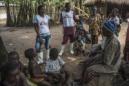 Fotografía facilitada por Médicos Sin Fronteras (MSF). Emma Kamara (i) y Joseph Fofana (c) hablan a los aldeanos sobre medidas saludables para supervivientes de ébola en el distrito de Tonkilili. EFE