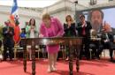 Fotografía cedida por la Presidencia de Chile, este 9 de enero de 2015, que muestra a la presidenta chilena, Michelle Bachelet (c), durante la firma de un proyecto de ley que establece un Sistema de Protección Financiera para Tratamientos de Alto Costo y que se tramitará en el Congreso en los próximos días, en el Palacio de la Moneda de Santiago de Chile (Chile). EFE
